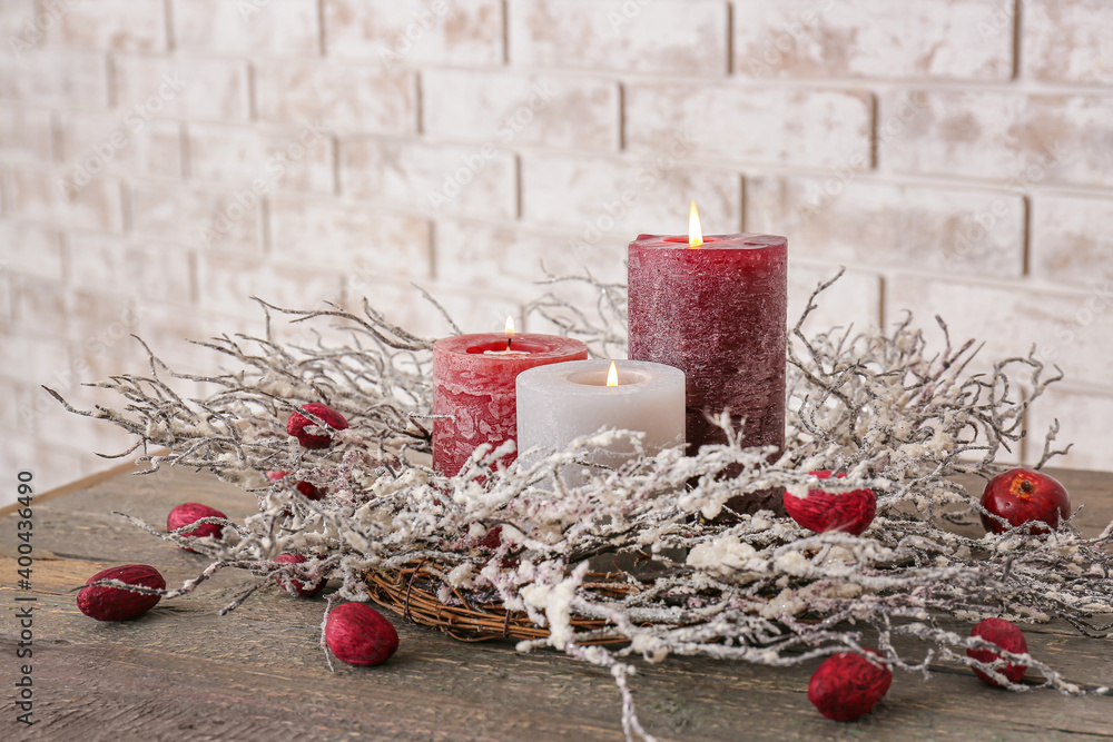 Beautiful aroma candles with Christmas decor on table