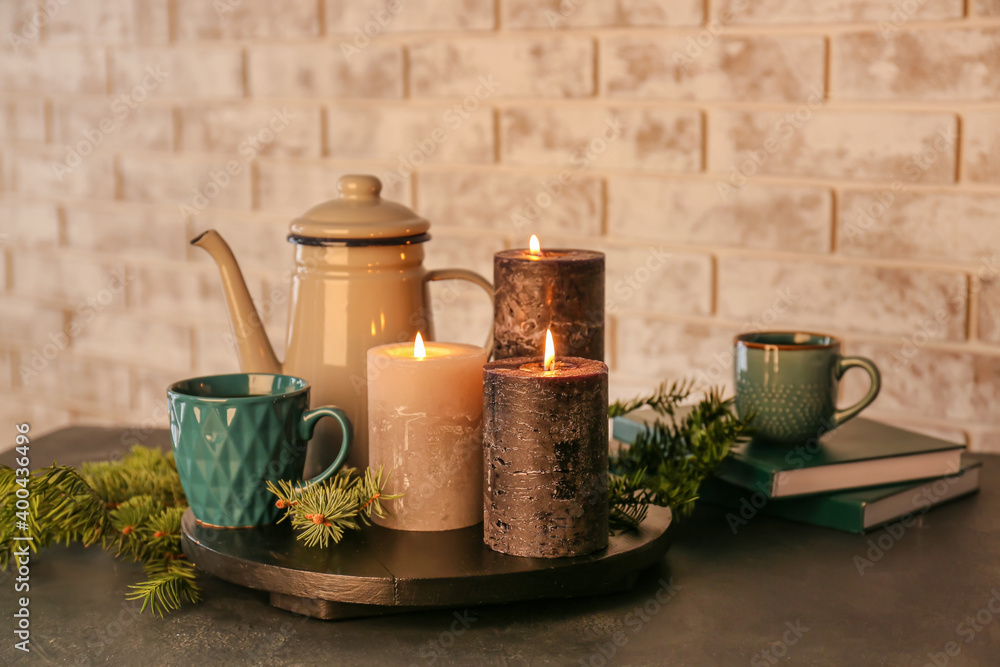 Beautiful aroma candles with tea and fir tree branches on table