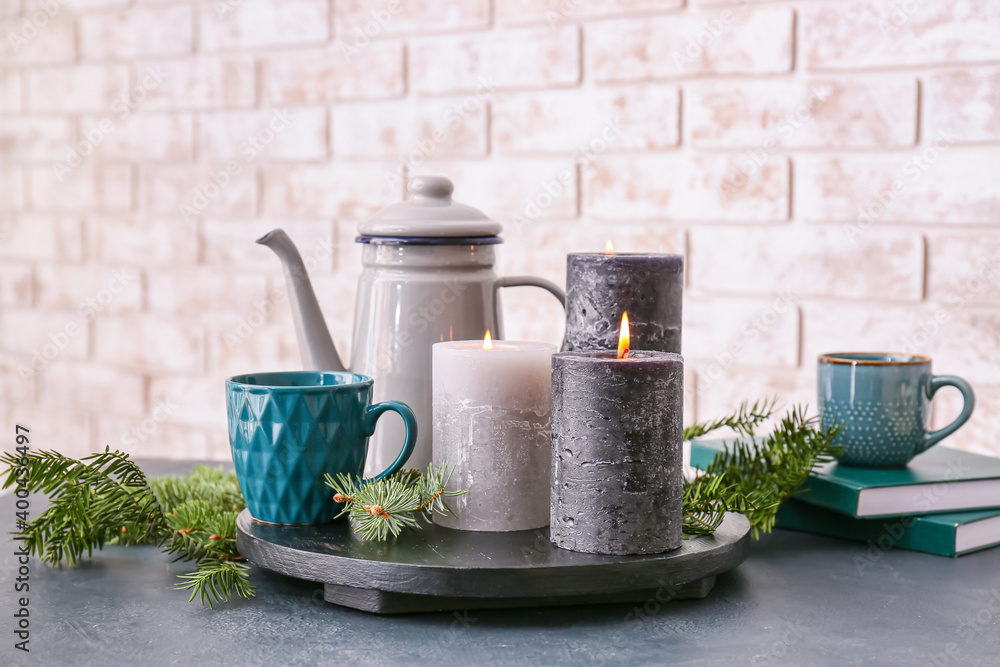 Beautiful aroma candles with tea and fir tree branches on table