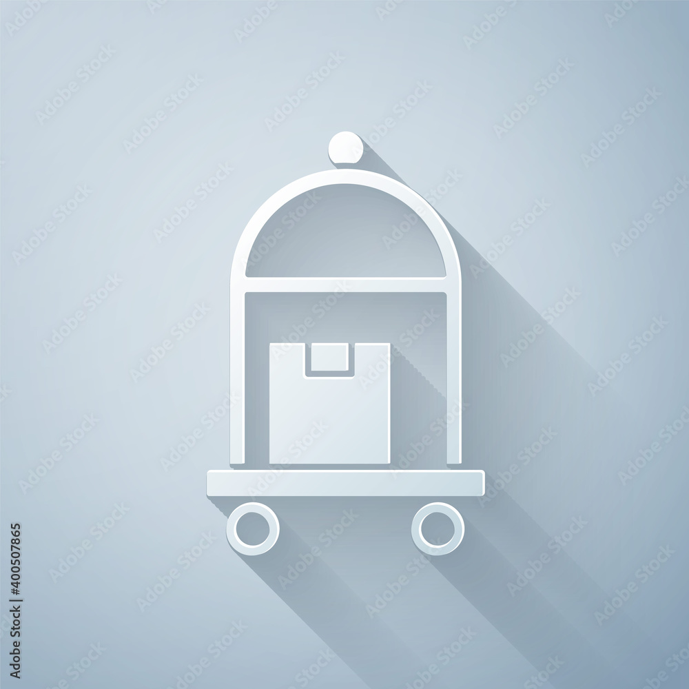 Paper cut Hotel luggage cart with suitcase icon isolated on grey background. Traveling baggage sign.