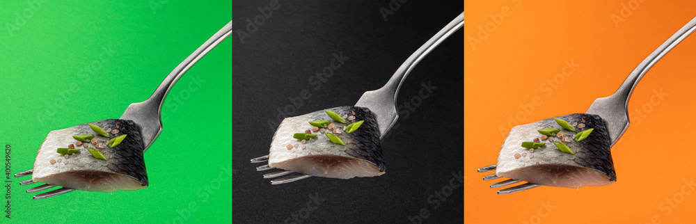 Pieces of salted herring on fork