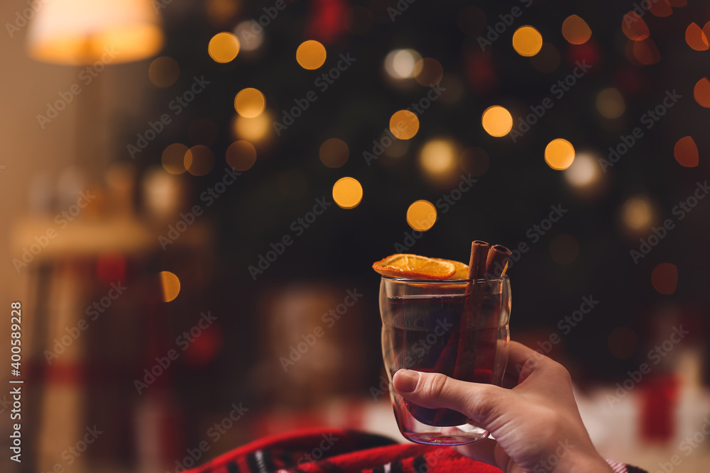 Woman with tasty mulled wine at home on Christmas eve