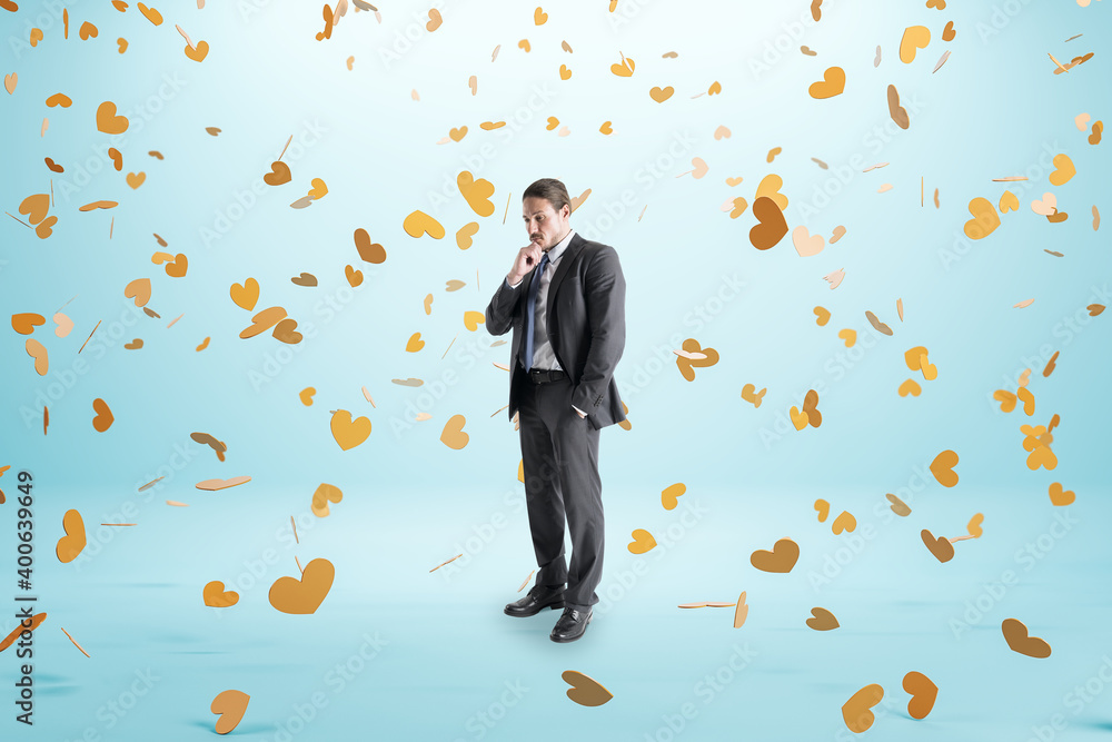 Pensive businessman and flying golden heart symbol