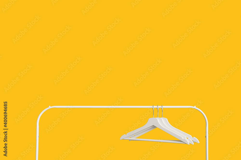 Rack with clothes hangers on color background