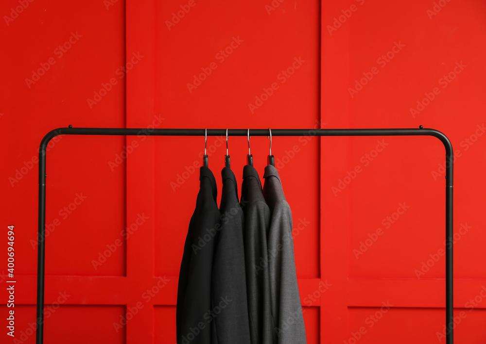 Rack with clothes on color background