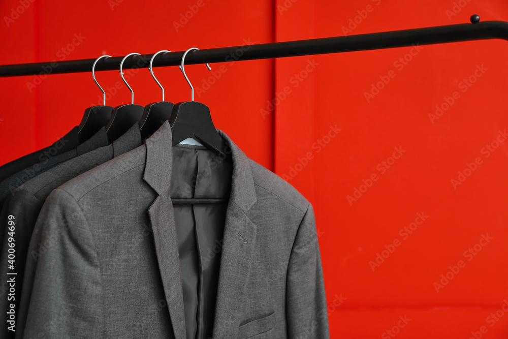 Rack with clothes on color background