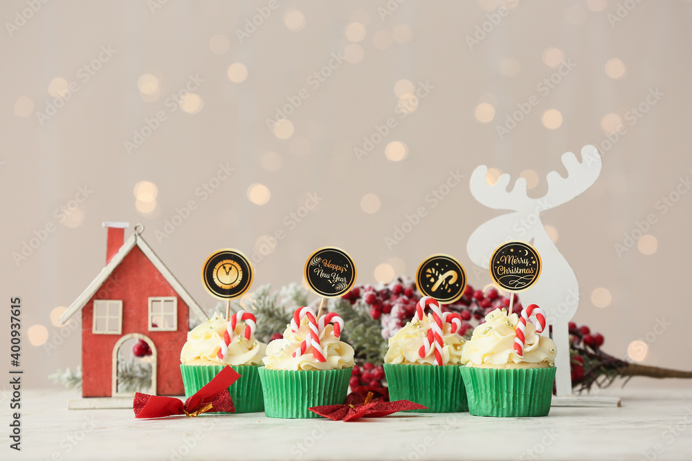 Tasty Christmas cupcakes on blurred background