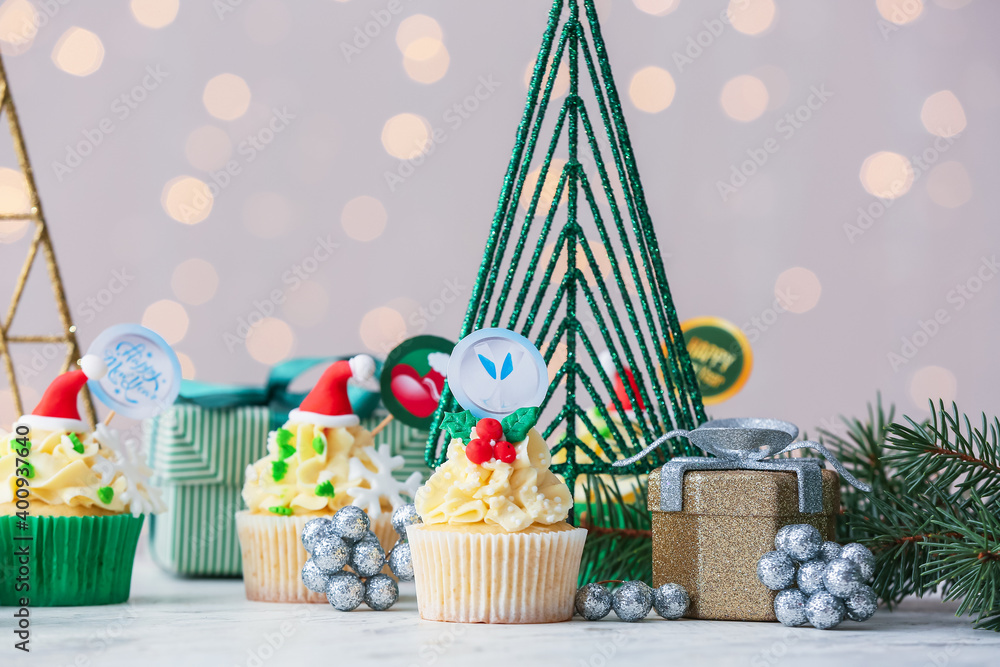 Tasty Christmas cupcakes on blurred background