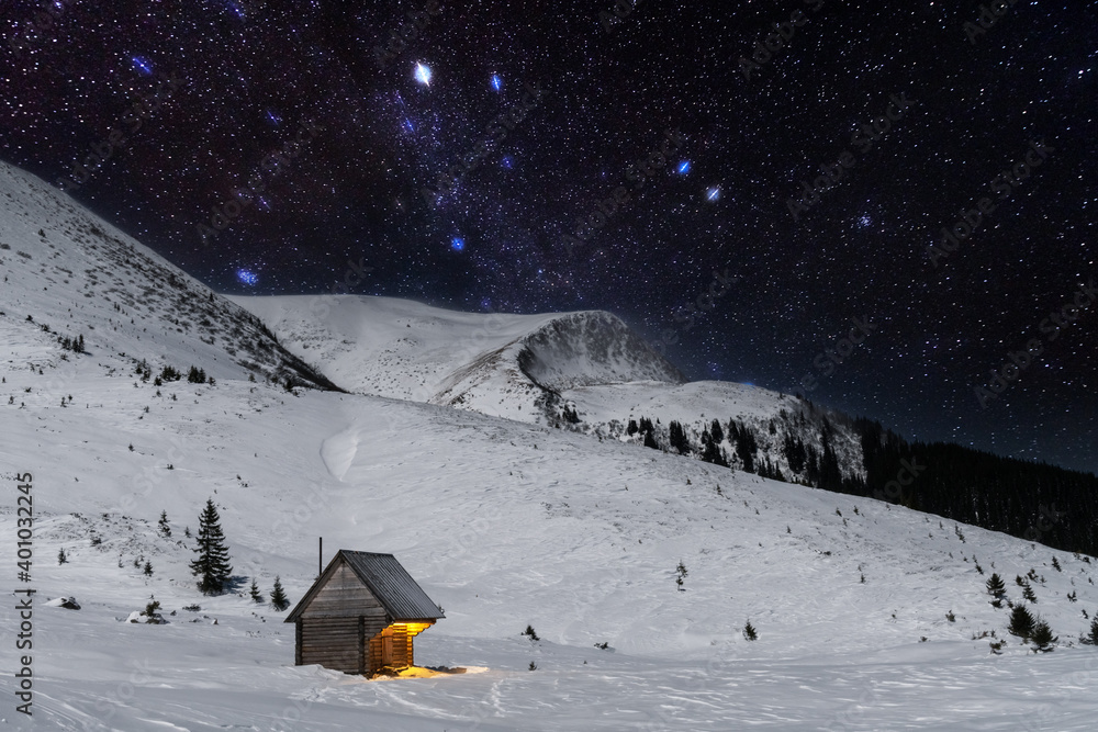 雪山木屋的奇妙冬季景观。银河和雪的星空