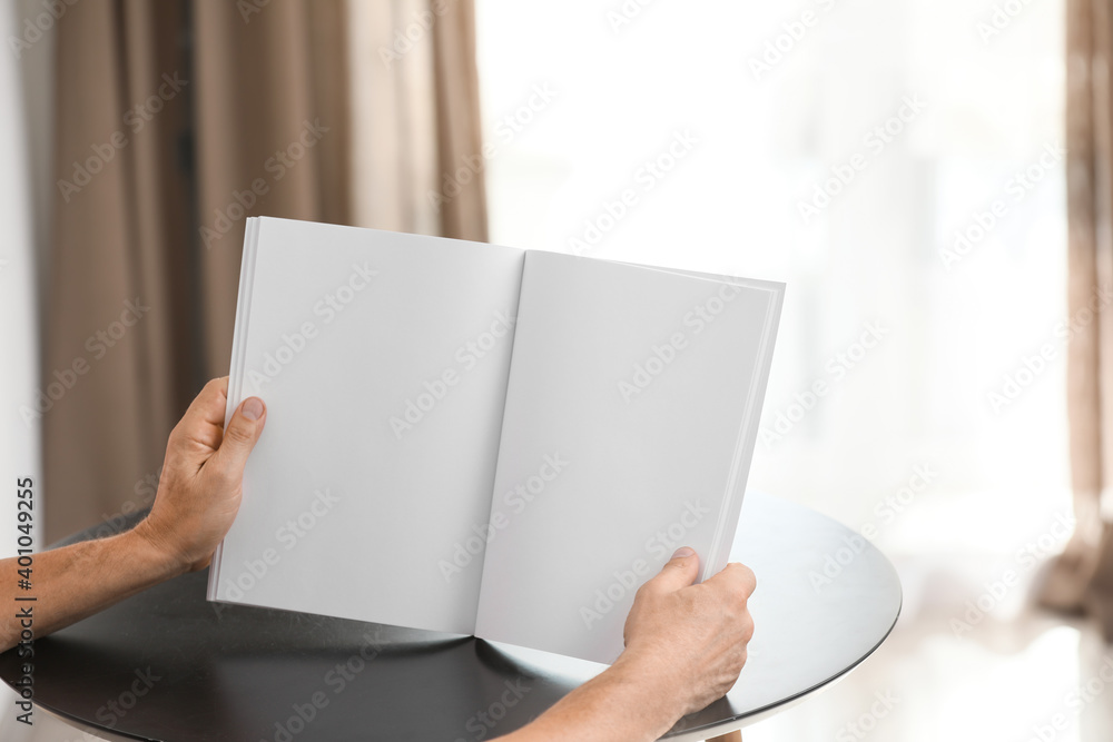 Old man with blank magazine at home