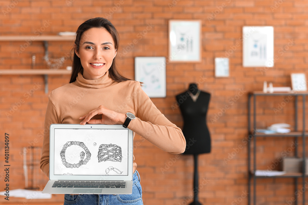 Female jewelry designer with laptop working in office