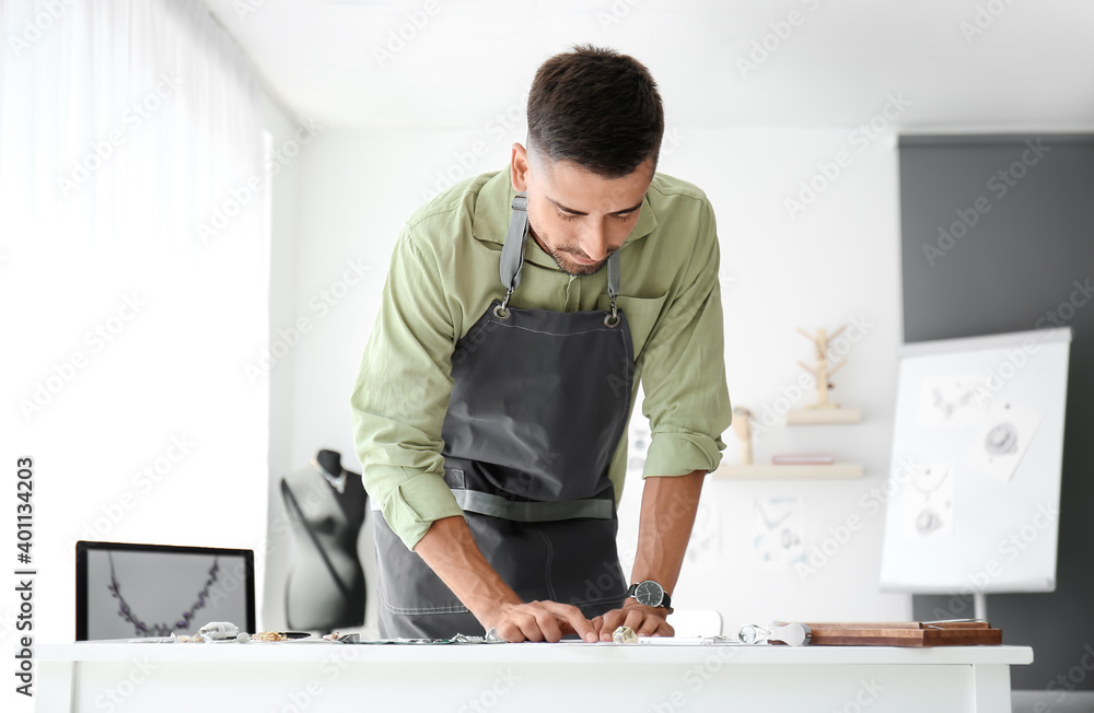 Male jewelry designer working in office