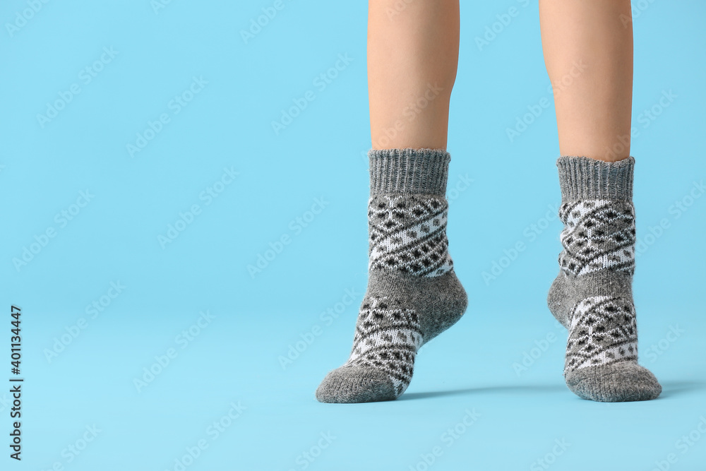 Legs of young woman in socks on color background