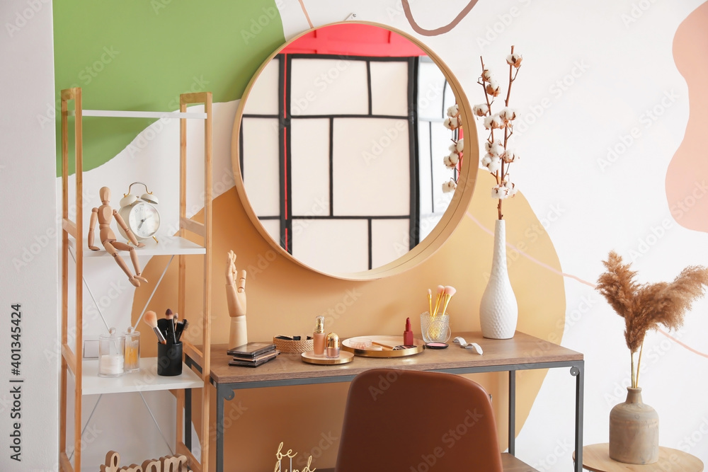 Table with mirror and decorative cosmetics in modern makeup room