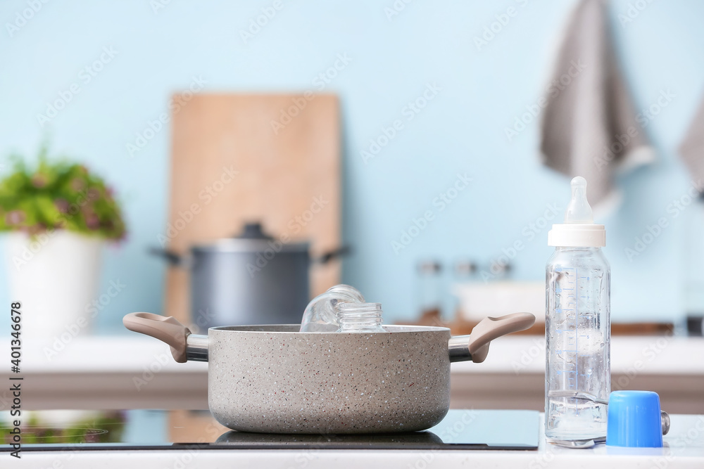 Cleaning of baby bottles in kitchen