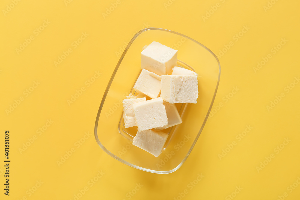 Box with fresh butter on color background