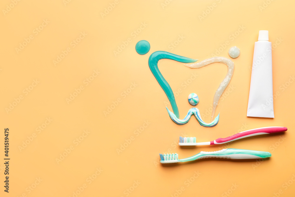 Composition with toothbrushes and paste on color background