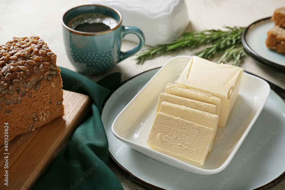 Fresh butter and tasty bread on table