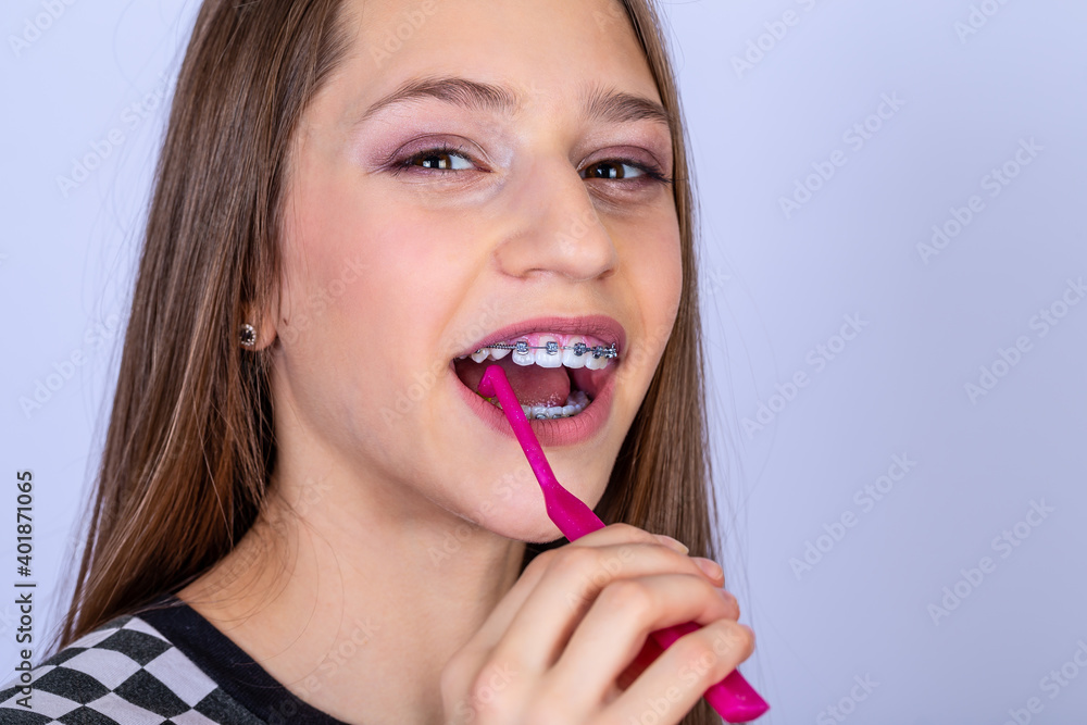 Dentist and orthodontist concept. Girl with braces cleaning teeth using brushes