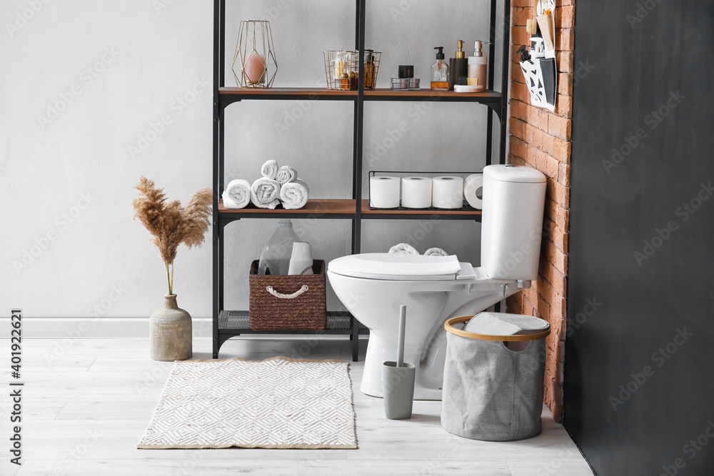 Stylish shelf and toilet bowl in interior of modern bathroom