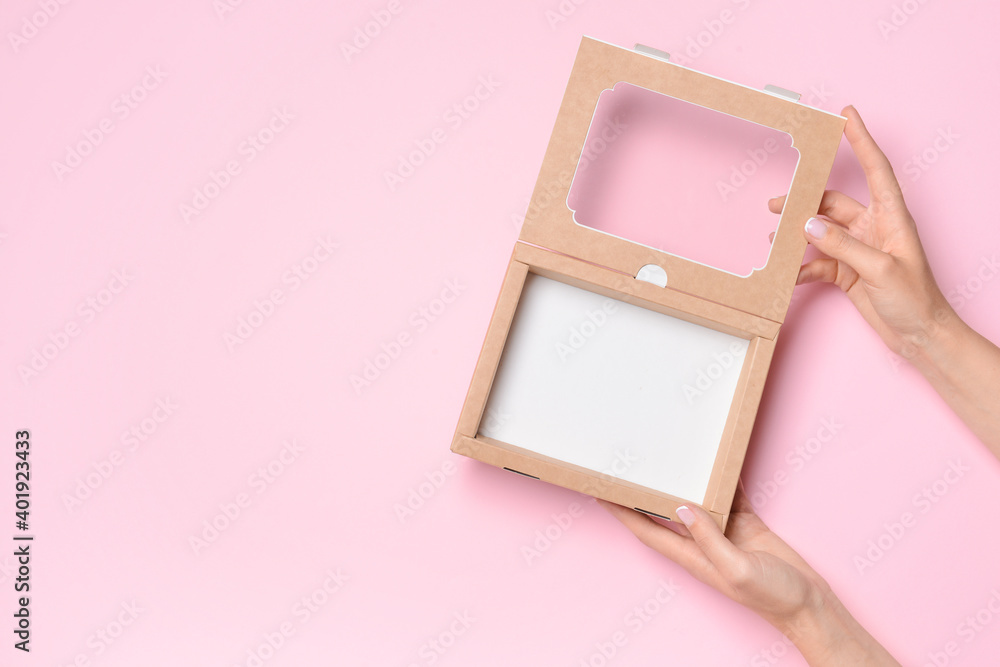 Hands with cardboard box on color background