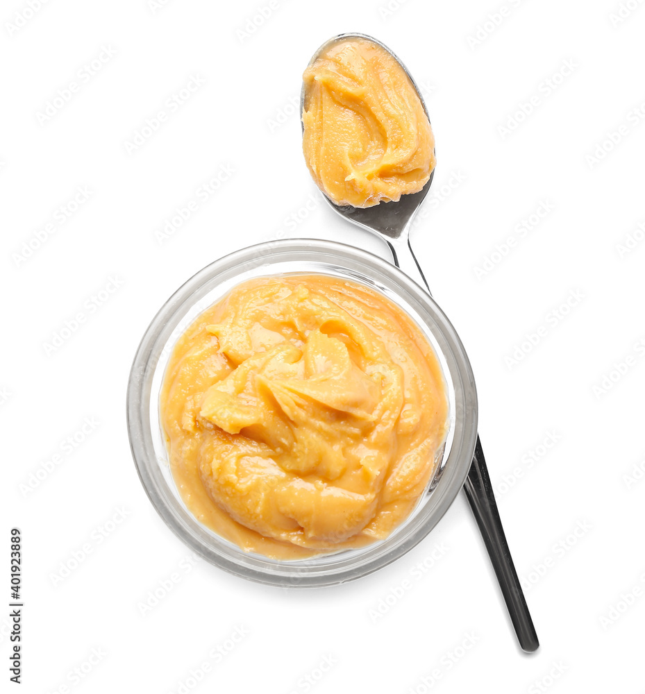 Bowl of peanut butter and spoon isolated on white background