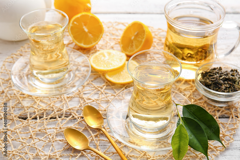 Composition with cups of green tea and lemon on table