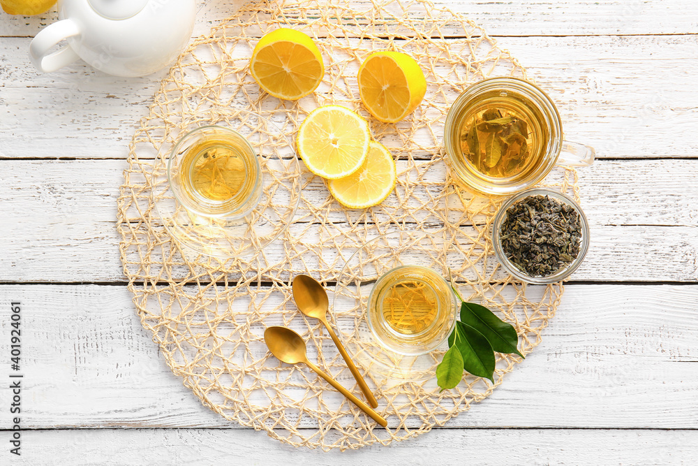 Composition with cups of green tea and lemon on table