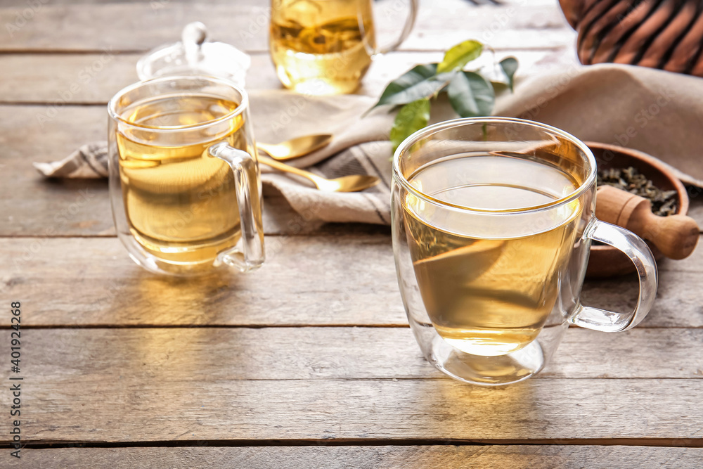 Composition with cups of green tea on wooden table