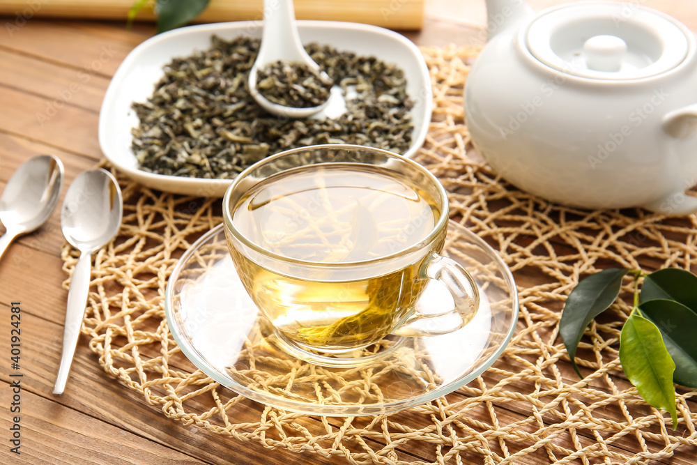 Composition with cup of green tea on wooden table