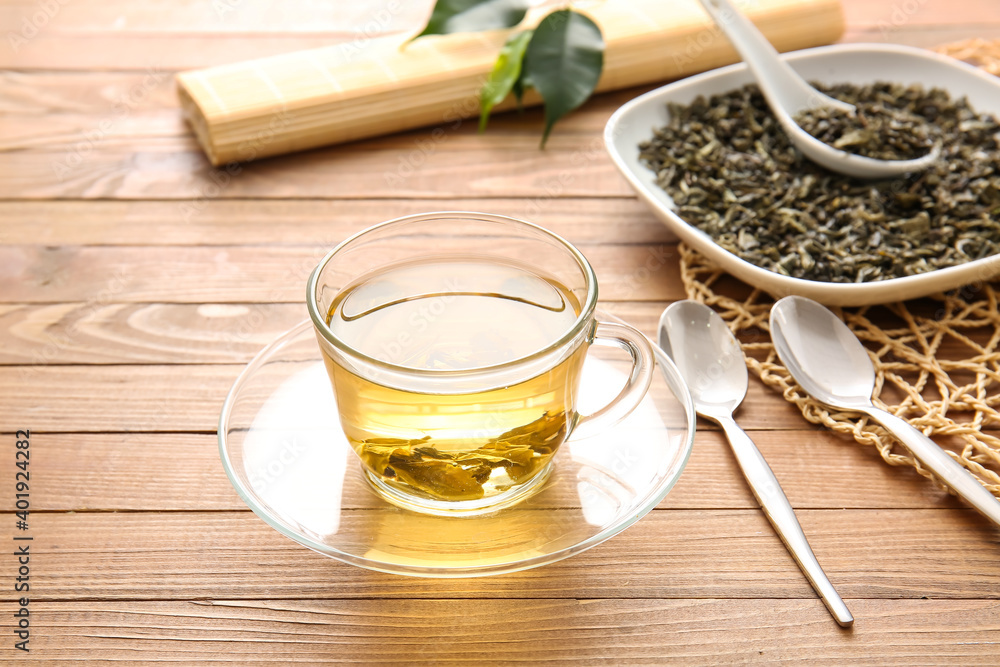 Composition with cup of green tea on wooden table