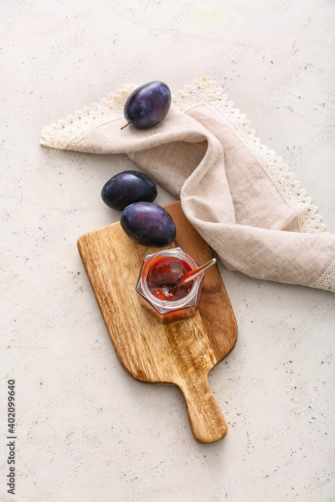 Glass jar with delicious homemade plum jam on table