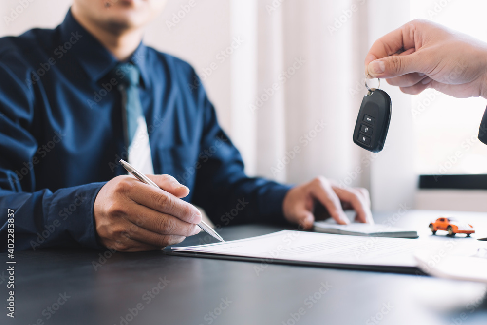 car salesman handing over your new car keys, dealership and sales concept