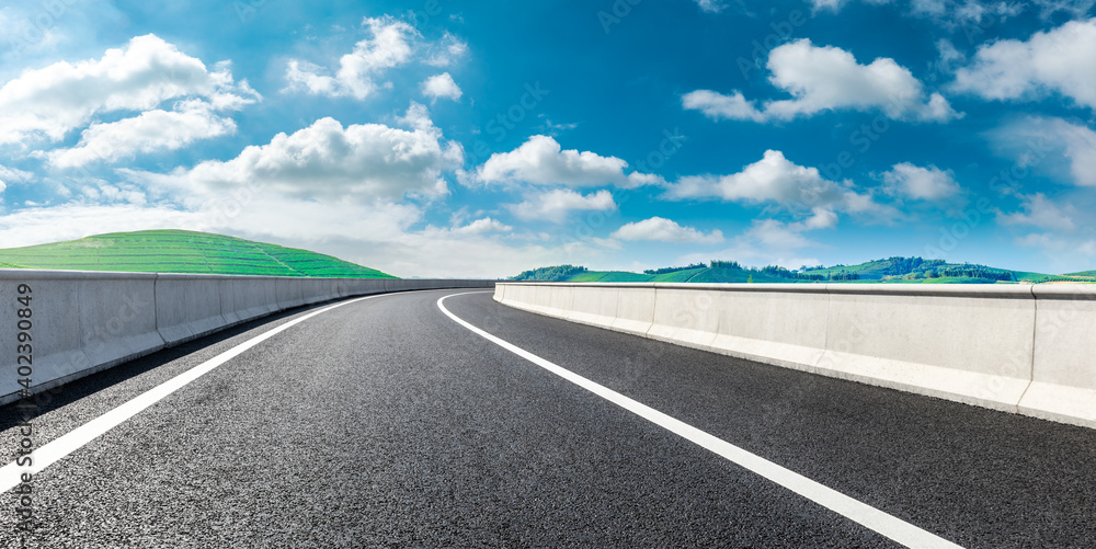 Asphalt road and mountain with tea plantation under blue sky.Road and mountain background.