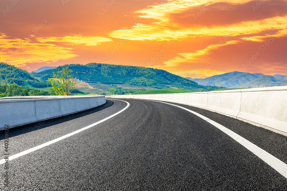 Asphalt road and mountain at sunset.Road and mountain background.