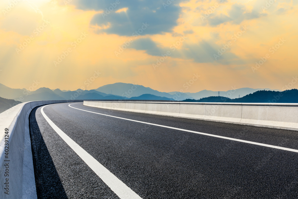 Asphalt road and mountain at sunset.Road and mountain background.