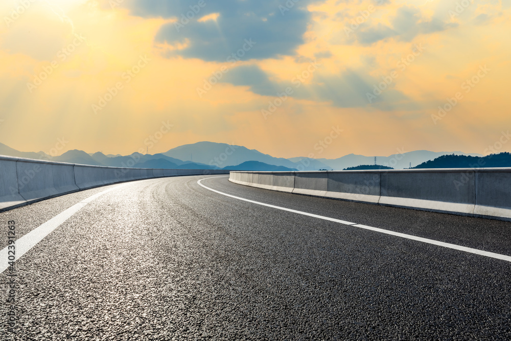 Asphalt road and mountain at sunset.Road and mountain background.