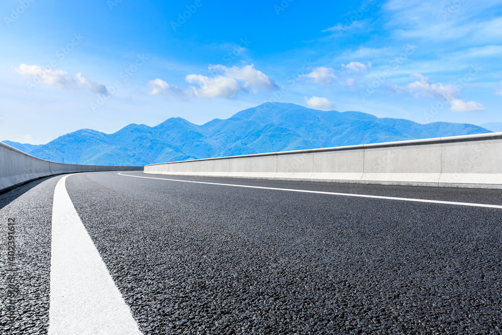 Asphalt road and green mountain under blue sky.Road and mountain background.