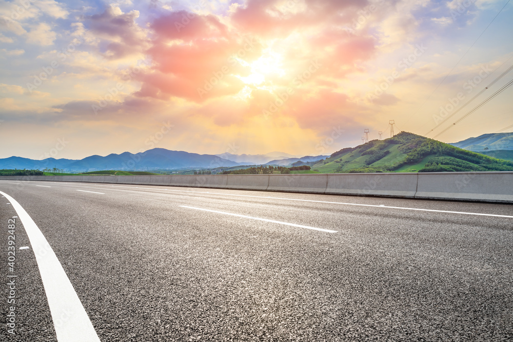 Asphalt road and mountain at sunset.Road and mountain background.