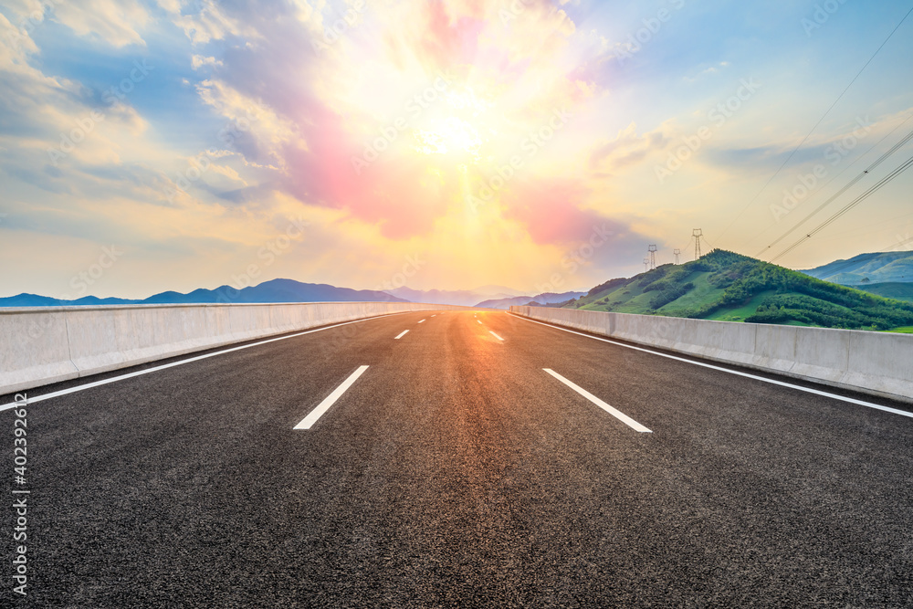 Asphalt road and mountain at sunset.Road and mountain background.