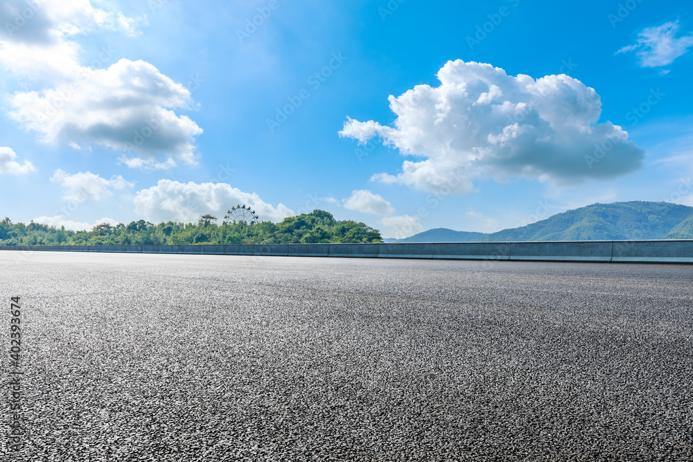 Asphalt road and green mountain under blue sky.Road and mountain background.