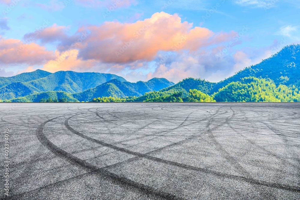 日落时的沥青路面和山脉。赛道道路和山脉背景。