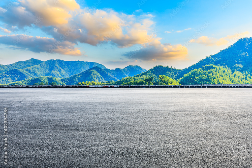 日落时的沥青路面和山脉。赛道道路和山脉背景。