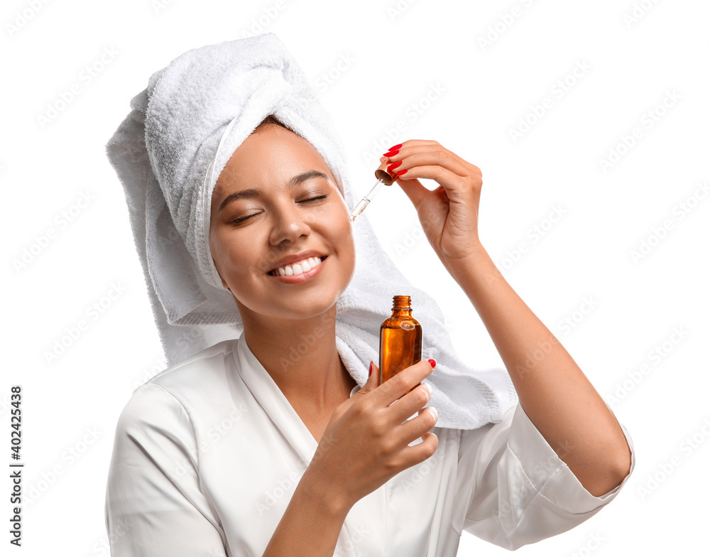 Beautiful young woman with cosmetic oil on white background