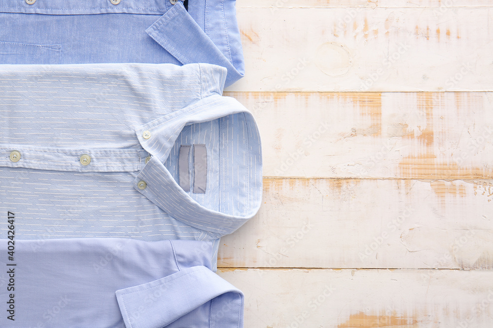 Folded male shirts on wooden background