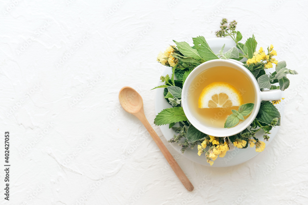 Cup with herbal tea on light background