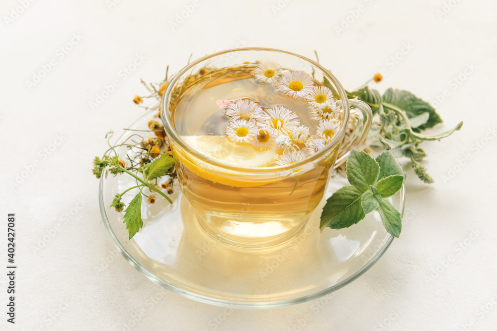 Cup with herbal tea on light background