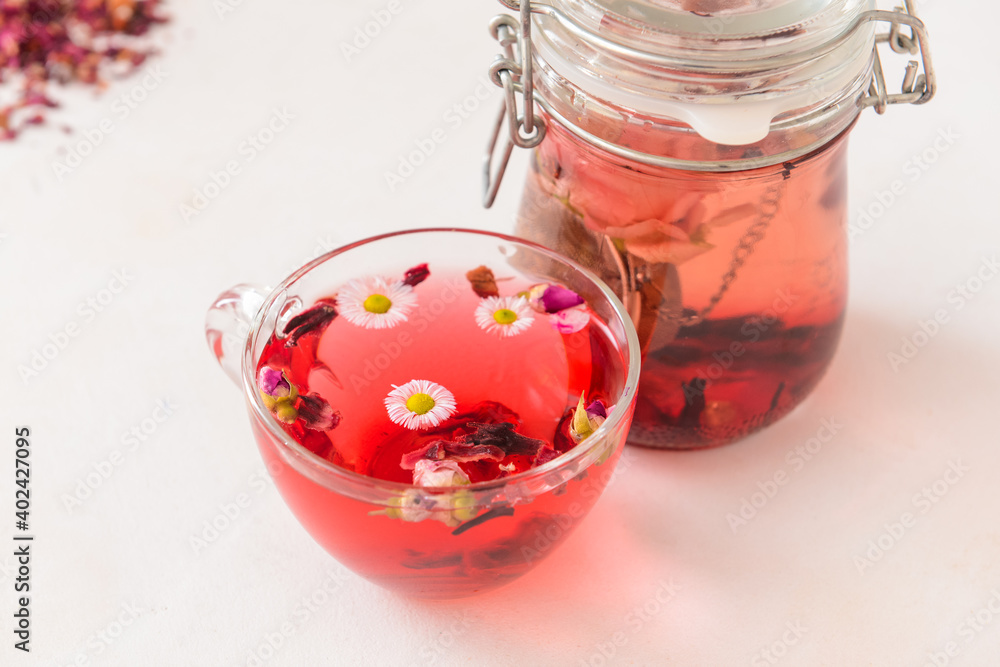 Flowers, teapot and cup with floral tea on light background