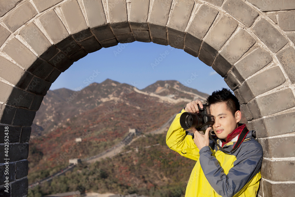 一个年轻人在长城旅游中拍照