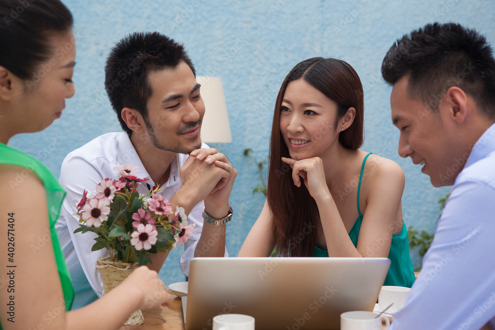 Four people sit together working with computers 